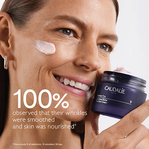 Image 1 - A woman smiles while applying a pink cream to her cheek, holding a jar labeled Caudalie Premier Cru La Crème Riche, with the text 100% observed that their wrinkles were smoothed and skin was nourished*.
Image 2 - Image shows a jar of Caudalie Premier Cru La Crème Riche The Rich Cream, surrounded by dark grapes, against a purple background, with text highlighting natural plumping filler, longevity patent, and bio-ceramides.
Image 3 - A close-up of a woman smiling while holding a bunch of dark grapes near her face, with text that reads Targets all signs of ageing followed by checkmarks for Wrinkles, Dark spots, and Volume.
Image 4 - Side-by-side images of two cream products from Caudalie, one labeled The Cream and the other The Rich Cream, with text descriptions highlighting their benefits and textures: The Cream targets wrinkles, dark spots, and volume for all skin types with a cream texture, while The Rich Cream also addresses the same issues but is formulated for dry skin with a rich texture.
Image 5 - Image of two jars of Caudalie Premier Cru The Rich Cream against a dark background, with the text New Premier Cru The Rich Cream and details about the new longevity formula and natural plumping filler from rosewood.
Image 6 - Image shows four different types of skincare creams arranged in a vertical layout on a purple background, labeled from top to bottom as The Serum, The Cream, The Rich Cream, and The Eye Cream.
Image 7 - An image showing a hand holding a jar of Premier Cru The Rich Cream with steps on recycling it, including keeping the glass jar and cover, recycling the empty refill, and inserting a new refill into the jar; the visible text reads: How to recycle Premier Cru The Rich Cream 1 Keep the glass jar and the cover 2 Recycle the empty refill in the recycling bin 3 Insert a new refill into your jar.