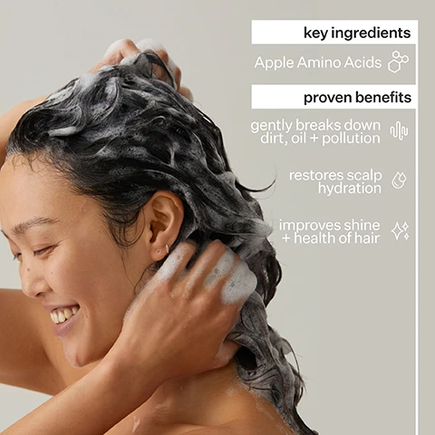 Image 1 - A woman is washing her hair with shampoo, lathering it with her hands, and on the right side of the image are text boxes listing key ingredients and proven benefits, including Apple Amino Acids, gently breaks down dirt, oil + pollution, restores scalp hydration, and improves shine + health of hair.
Image 2 - Image showing two close-up views of a hair parting: the left image labeled Before shows dry and unhealthy-looking hair with visible flakes, while the right image labeled After shows smooth, healthy-looking hair without flakes.
Image 3 - A split image shows a woman with wavy hair on the left labeled Before and the same woman with smooth, styled hair on the right labeled After.
Image 4 - Image shows a list of ingredients and production details for Hair Cleanse Shampoo, including Apple Amino Acids, Baobab Oil, and Glycerin with descriptions, and production and packaging information detailing ethical labor, manufacturing method, and recyclability.
Image 5 - Image showing a graphic titled Why Cold Processed® with a background of liquid and round droplets; it includes a bar graph illustrating that 97% of nutrients are retained with Cold Processed® method, and 10% with heat processing, with a note that Cold Processing preserves active ingredients while heat destroys them.