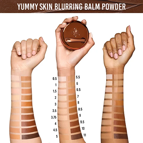 Image 1 - Image shows two arms with swatches of various shades of foundation, the left arm displaying lighter shades and the right arm displaying darker shades, while a hand holds a round container of Blurring Balm Powder, with visible text reading YUMMY SKIN BLURRING BALM POWDER at the top and shade numbers listed next to the swatches.
Image 2 - A close-up image of a smiling woman with medium skin tone, showing her face split into two halves to display a before and after effect of a beauty product; the left side is shiny and labeled Yummy Before, Wears Like Makeup, and the right side appears matte with the label Yummier After, Works Like Skincare, above both sections.
Image 3 - Image shows three portraits of a woman with braided hair: the first on the left displays her bare skin labeled as BEFORE, the middle image shows her with a blurring balm powder primer, and the right image presents her with a finished makeup look including foundation, with product details and text YUMMY SKIN BLURRING BALM POWDER at the top and WEAR ALONE OR UNDER YOUR FAVORITE FOUNDATION FOR A BLURRED FILTER below.
Image 4 - Image shows a woman with blonde hair, displayed in two sections: the left side labeled Blurring Balm Powder Radiant features a luminous finish, while the right side labeled Blurring Balm Powder Universal shows a matte finish; two compact containers are visible at the bottom, labeled Luminous Blur and Matte Blur.
Image 5 - Image shows two containers of Yummy Skin Blurring Balm Powder primer with Universal and Radiant finishes, alongside descriptions for Matte Blur with soft matte finish and Luminous Blur with soft glow finish, stating the formula adapts to control sweat and oil all day, while promoting smoother skin appearance.
Image 6 - Four women of diverse skin tones are shown in a grid holding a cosmetic product in a compact container, with the text TRANSLUCENT ON ALL SKINTONES AWARD WINNING • TEXTURE REDUCING • ABSORBS SWEAT & OIL displayed at the top.
Image 7 - A smiling person with blonde hair holds a container of Yummy Skin Blurring Balm Powder while showcasing another powder compact, with text stating 96% said it made their foundation apply smoothly and 93% said it helped to blur the appearance of pores.
Image 8 - Image shows a four-part tutorial for applying blurring balm powder with diverse individuals demonstrating each step, featuring text that reads: Choose your primer: Radiant for a soft glow finish or Universal for a soft matte finish, Spoon out a dime-sized amount with included spatula, Using a brush or your fingertips, smooth a thin, even layer over the skin and blend, Let set for 60 seconds and apply your favorite foundation for a smooth blurred finish.
