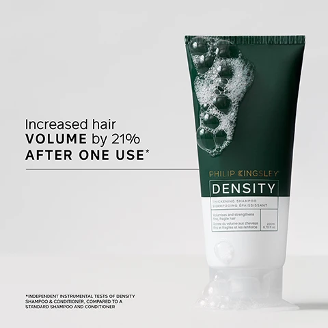 Image 1 - A tube of Philip Kingsley Density thickening shampoo with a dark green label and bubbles around it, featuring the text Increased hair VOLUME by 21% AFTER ONE USE* below, and an asterisk indicating additional information about the results.
Image 2 - A person holds a tube of Philip Kingsley Density hair product while displaying a small amount of the product in their other hand; visible text includes a customer review stating My hair feels THICK, FULLER and more VOLUMISED. Its a very noticeable difference. I noticed this difference after the 1st wash and a note that says *USER TRIAL PANEL COMMENT.
Image 3 - Image shows the back view of a persons hair styled in two different looks; the left side labeled Before displays messy, unkempt hair, while the right side labeled After shows a more polished, voluminous hairstyle.
Image 4 - A close-up of a hand applying water and shampoo to wet hair, accompanied by the text TRICHOLOGIST TIP Wet hair and lather well with a gentle kneading of the scalp for 60 seconds.