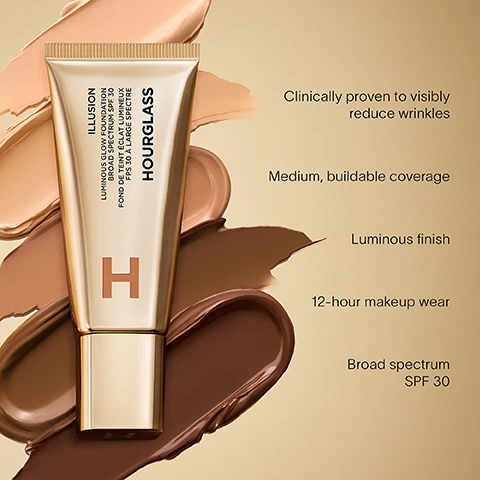 Image 1 - A gold tube of Hourglass Illusion foundation is centered among swatches of foundation in varying shades, with visible text stating Clinically proven to visibly reduce wrinkles, Medium, buildable coverage, Luminous finish, 12-hour makeup wear, and Broad spectrum SPF 30.
Image 2 - A close-up portrait of a woman with light skin and blue eyes, wearing a simple earring and holding her head with one hand, accompanied by the text 90% said product didn’t crease all day.
Image 3 - A woman with medium skin tone holds a gold tube of Hourglass Illusion foundation near her face, showcasing her smooth skin, and text on the image reads 90% said skin texture improved after 2 weeks.
Image 4 - A close-up of a person with smooth skin holding a tube of Hourglass cosmetic product next to their face, with text stating 93% said skin instantly looks and feels smoother.
Image 5 - A gold tube of Hourglass Illusion Luminous Glow Foundation is shown against a soft, neutral background, with text that reads Advanced Hydra-Smoothing Technology A blend of hyaluronic microspheres that help retain moisture to visibly smooth fine lines and wrinkles.