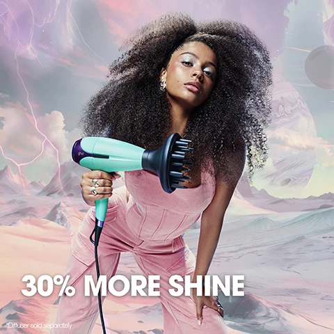 Image 1 - A person with curly hair holds a turquoise hairdryer in a futuristic landscape, with the text 30% MORE SHINE and Diffuser sold separately visible at the bottom.
Image 2 - A turquoise hairdryer is positioned on a matching cloth, with the text INCLUDES DUST BAG in colorful letters on the right side.
Image 3 - An assortment of hair styling tools including a hairdryer, two hair straighteners, a round brush, and a styling brush, all displayed on a reflective surface, with visible text stating NEW GHD LIMITED EDITION FUTURESCAPE COLLECTION and FEATURING OUR AWARD-WINNING TOOLS.
Image 4 - A diverse group of five individuals poses confidently with hair styling tools against a pastel sky, with the text ITS NOT A.I. ITS GHD prominently displayed above them.