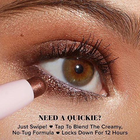 Image 1 - A close-up of a womans eye showing a bronze eyeshadow applied along the eyelid, with a makeup pencil just below the eye, and visible text that reads NEED A QUICKIE? Just Swipe! Tap To Blend The Creamy, No-Tug Formula Locks Down For 12 Hours.
Image 2 - A close-up image of an eye with shimmering eyeshadow, alongside a pink makeup pencil, featuring text that reads Creamy Formula Doesn’t Tug, 12-Hour Wear, Easy Swipe & Go Color, High-Impact Sparkle, Non-Caking & Non-Creasing.
Image 3 - Three arms showcasing various cream eyeshadow swatches in different shades, labeled from top to bottom as Chocolate Sprinkles, Pure Magic, Charmed, Love Stone, Sunset Sizzle, Lilac Lust, Fairy Dust, and Twinkle, with the text Quickie Queen Cream Eyeshadow Stick at the bottom.