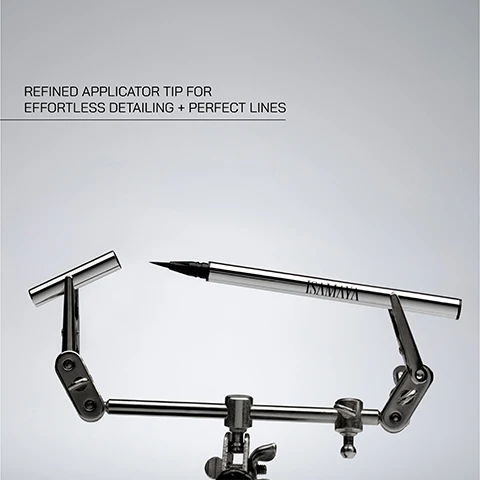Image 1 - A silver eyeliner pen is positioned between two metal clamps against a light gray background, with visible text that reads refined applicator tip for effortless detailing + perfect lines.
Image 2 - A close-up of a black liquid eyeliner applicator with a smooth line of eyeliner, accompanied by the text liquid formula for precision application.