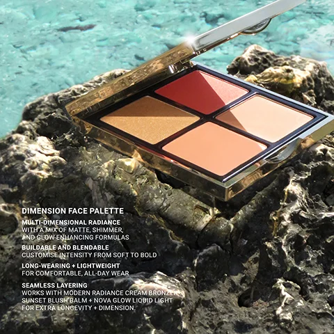 A makeup palette with four shades (red, gold shimmer, peach) is open on a dark rock with blurred turquoise water in the background: DIMENSION FACE PALETTE MULTI-DIMENSIONAL RADIANCE WITH A MIX OF MATTE, SHIMMER, AND GLOW-ENHANCING FORMULAS BUILDABLE AND BLENDABLE CUSTOMISE INTENSITY FROM SOFT TO BOLD LONG-WEARING + LIGHTWEIGHT FOR COMFORTABLE, ALL-DAY WEAR SEAMLESS LAYERING WORKS WITH MODERN RADIANCE CREAM BRONZER, SUNSET BLUSH BALM + NOVA GLOW LIQUID LIGHT FOR EXTRA LONGEVITY + DIMENSION.